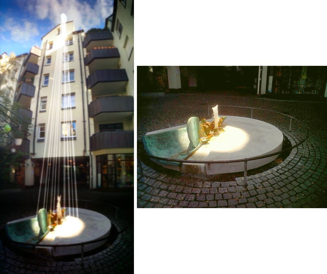 Nachgeführter Sonnenspiegel beleuchtet Brunnen in engem Altstadthof